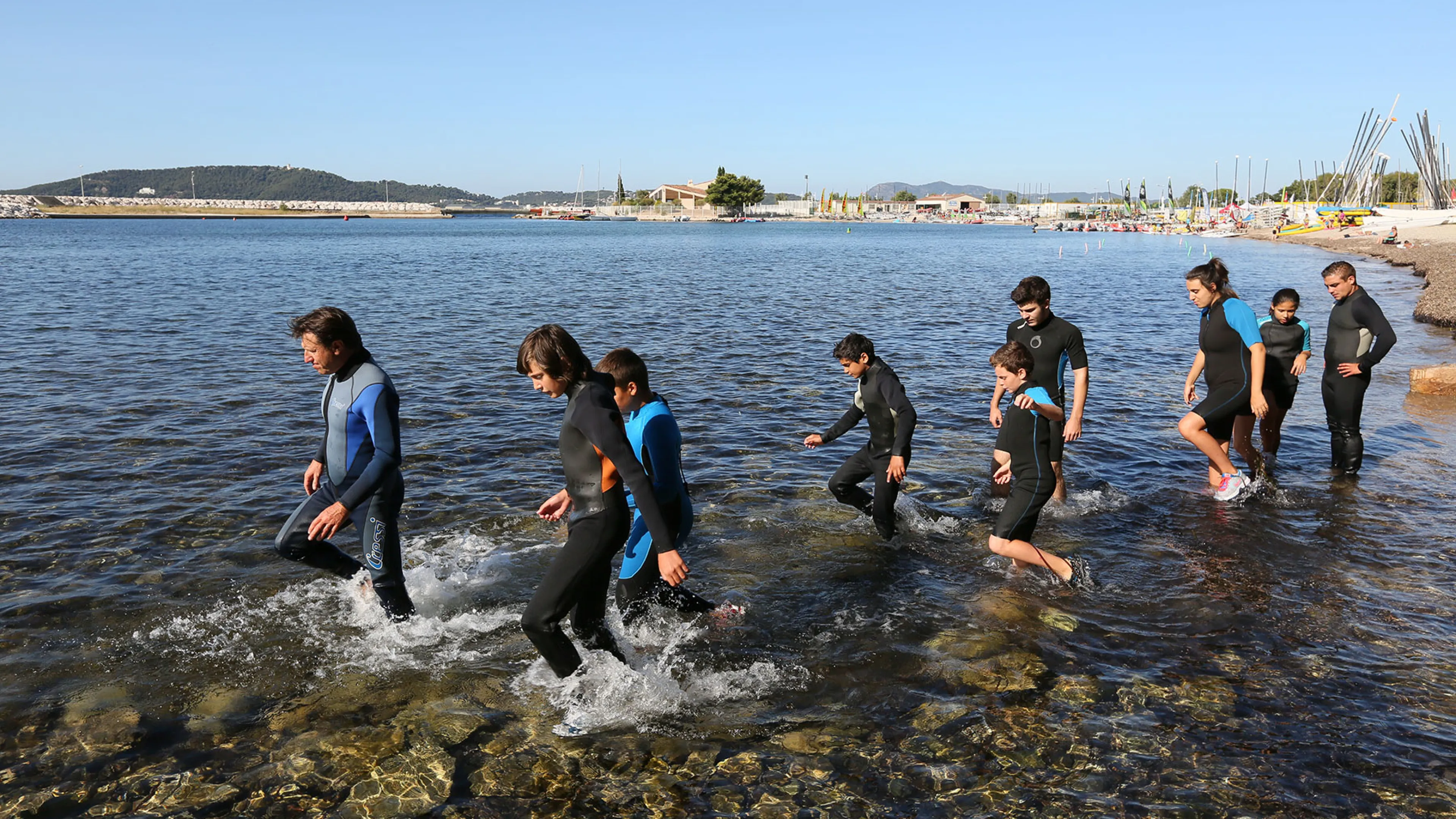 photographie de jeunes en combinaison de plongée au bord de l'eau à proche du yacht club toulonnais