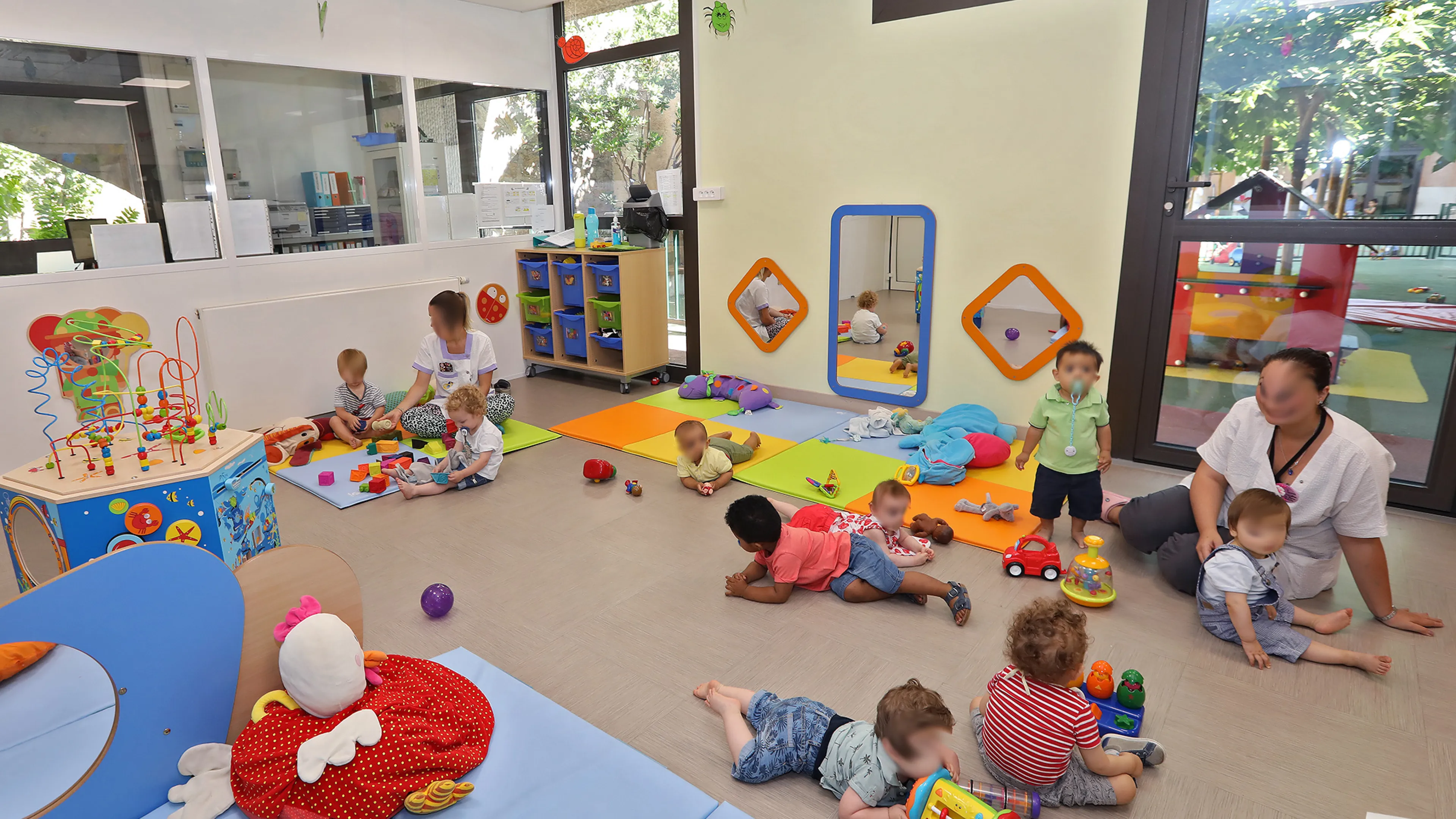 Photographie d'un groupe d'enfants dans une salle de classe en compagnie de deux adultes