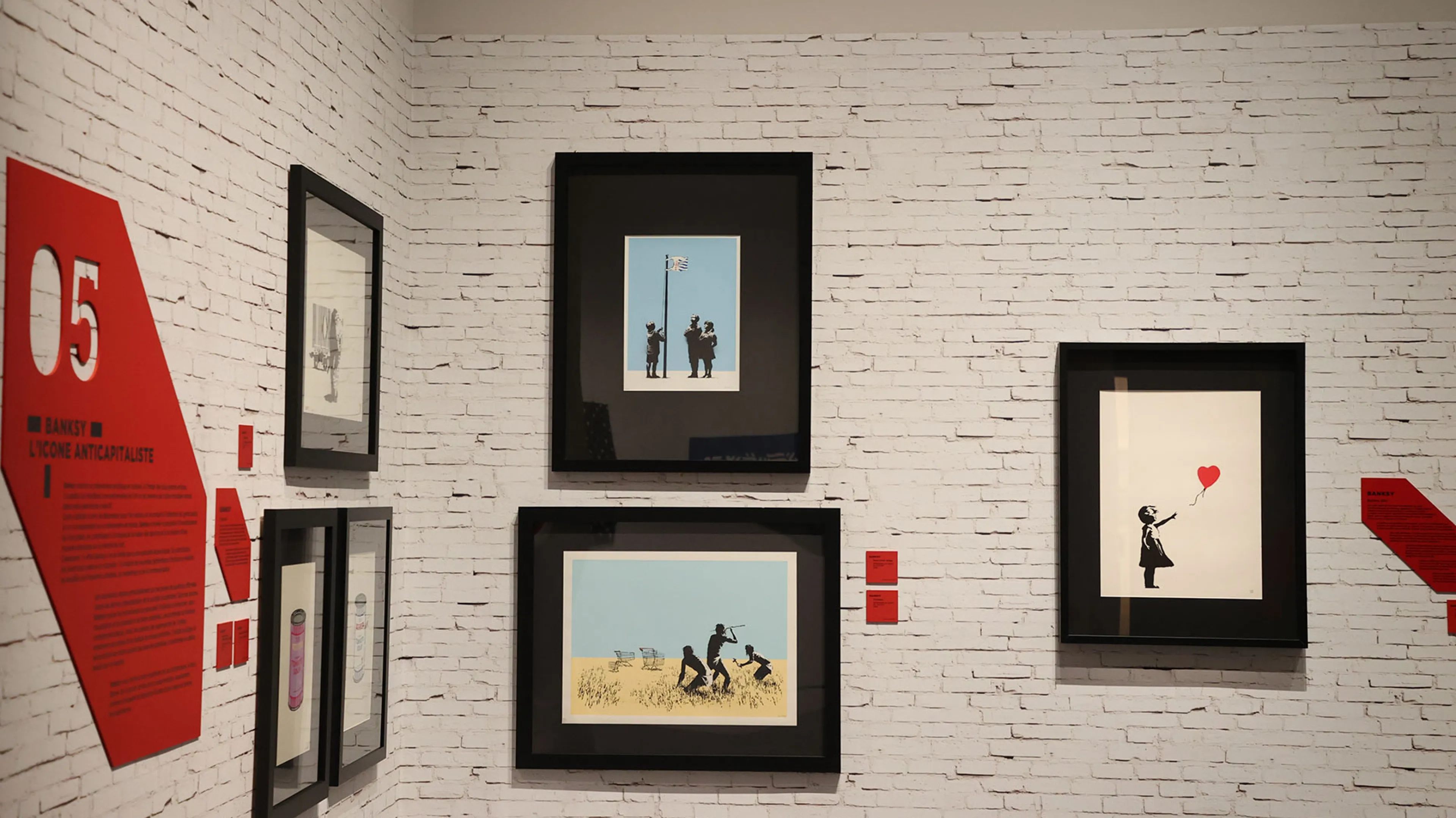 La photo présente 5 oeuvres de Banksy