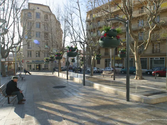 Place avec bancs donnant sur une fontaine et des jardinières