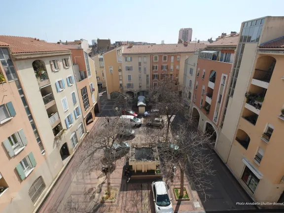 Vue aérienne sur la place sur laquelle des voitures sont garées.