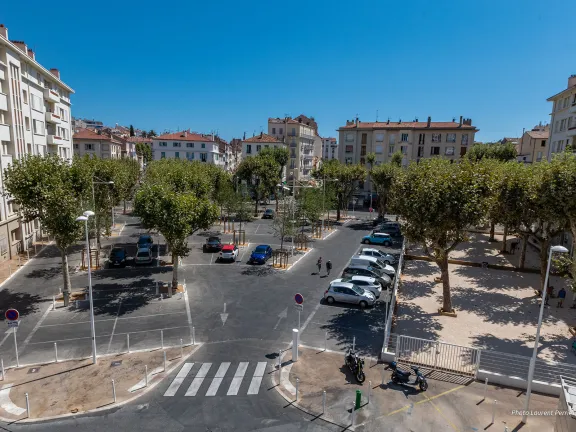 Place composée de places de parking, d'arbres et d'un boulodrome