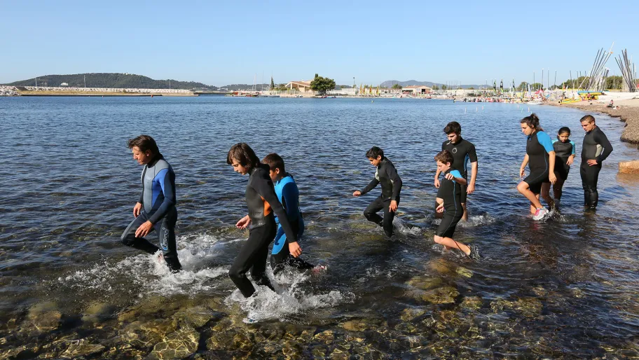 photographie de jeunes en combinaison de plongée au bord de l'eau à proche du yacht club toulonnais