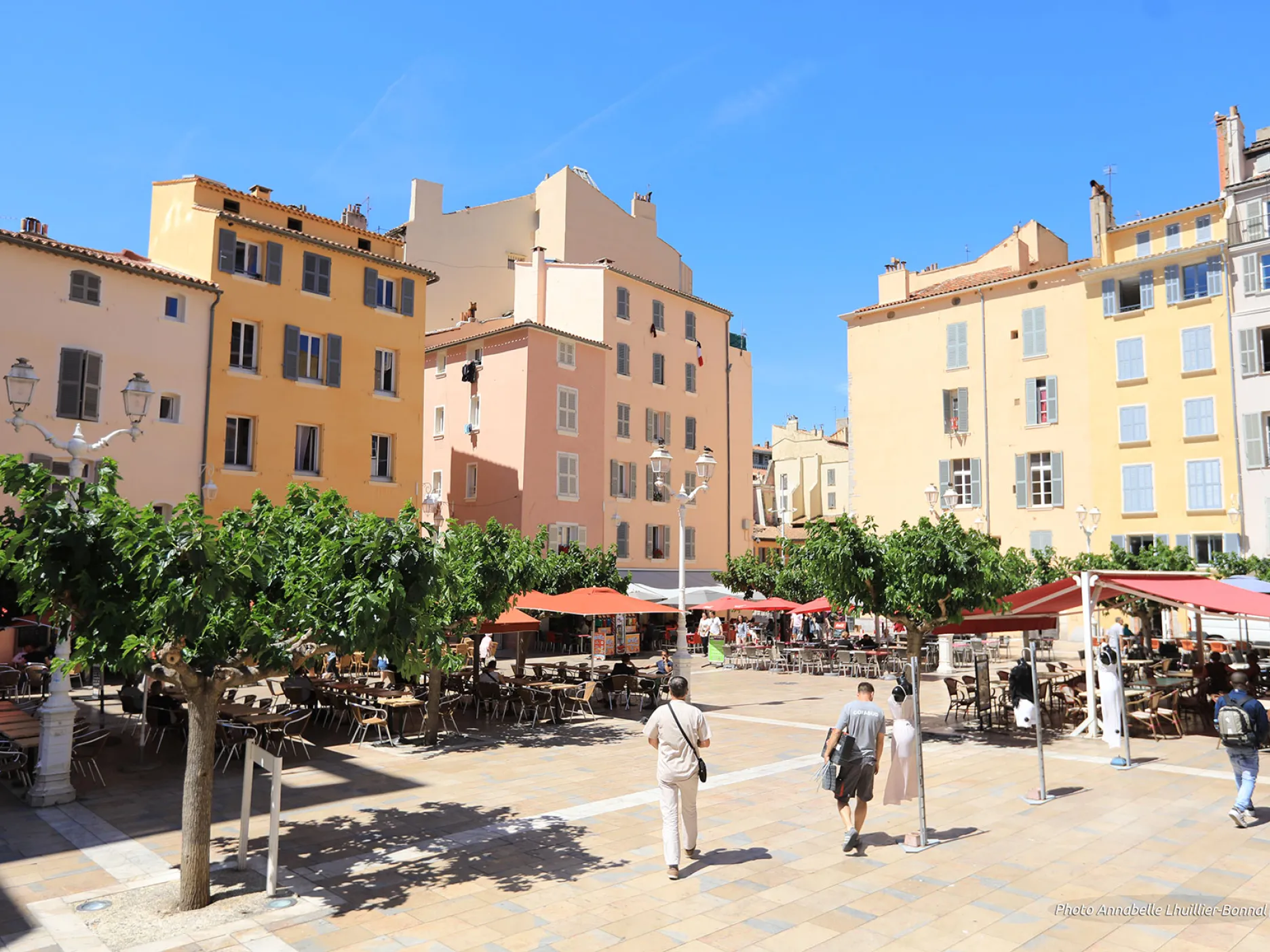 Vue sur les terrasses des restaurants entourées des facades colorées